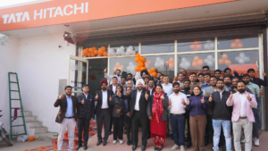 Exterior view of VMT Motors LLP Tata Hitachi dealership in Faridabad, featuring integrated sales, service workshop and genuine spare parts facility with the VMT Motors Team and esteemed customer and employees. 